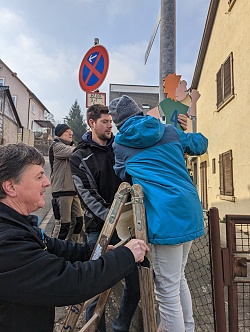 Mit Unterstützung eines Mietersheimer Schulkindes wird ein Schild Am Gänsberg angebracht. 